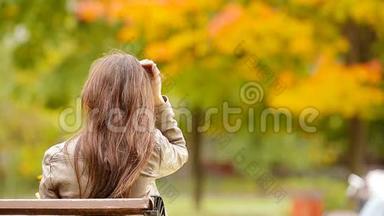 美丽的女人享受秋天公园秋天落叶下温暖的一天